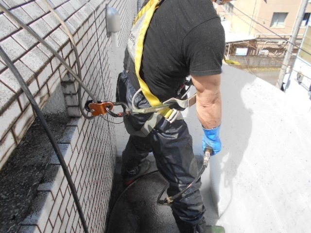 フルハーネス型墜落制止用器具を装着して外壁を洗浄する作業員